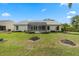 Spacious backyard with healthy green grass, trimmed bushes, and a screened patio, perfect for outdoor relaxation at 25274 Lost Oak Cir, Leesburg, FL 34748