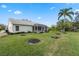 Expansive backyard with vibrant green grass, shade trees, and a screened-in porch, offering a serene outdoor experience at 25274 Lost Oak Cir, Leesburg, FL 34748