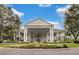 Elegant clubhouse featuring a grand entrance with columns, lush landscaping, and circular driveway for a luxurious welcome at 25274 Lost Oak Cir, Leesburg, FL 34748