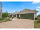 Well-maintained home with a brick driveway, lush landscaping, and a two-car garage at 25274 Lost Oak Cir, Leesburg, FL 34748