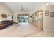 Spacious living room featuring vaulted ceilings, a ceiling fan, and sliding glass doors to a screened-in porch at 25274 Lost Oak Cir, Leesburg, FL 34748