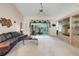 Spacious living room featuring vaulted ceilings, a ceiling fan, and sliding glass doors to a screened-in porch at 25274 Lost Oak Cir, Leesburg, FL 34748