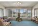 Relaxing sunroom features a ceiling fan, tiled flooring, and multiple windows overlooking the well manicured yard at 25274 Lost Oak Cir, Leesburg, FL 34748