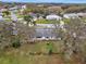 Mature trees and lush landscaping surround this aerial view of home and surrounding neighborhood at 27003 Racquet Cir, Leesburg, FL 34748