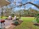 Relaxing back porch with outdoor seating overlooking the lush, landscaped backyard at 27003 Racquet Cir, Leesburg, FL 34748