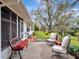 Cozy back porch features a bench, outdoor chairs, and landscaping with a view of the backyard at 27003 Racquet Cir, Leesburg, FL 34748