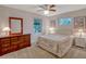 Cozy bedroom featuring a ceiling fan, white walls, carpeted floor, and natural light from two windows at 27003 Racquet Cir, Leesburg, FL 34748