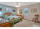 Cozy bedroom features a decorative quilt on the bed, ceiling fan, and natural light at 27003 Racquet Cir, Leesburg, FL 34748