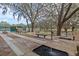 Community park featuring exercise areas, benches, trees with Spanish moss, and a nearby tennis court at 27003 Racquet Cir, Leesburg, FL 34748