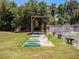 Outdoor driving range with multiple hitting bays and bench seating with mature trees and blue skies in the background at 27003 Racquet Cir, Leesburg, FL 34748