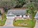 Aerial view of a charming single-Gathering home with a well-maintained lawn and a two-car garage at 27003 Racquet Cir, Leesburg, FL 34748