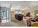 Bright living room featuring neutral tones, carpet floors, and a large window at 27003 Racquet Cir, Leesburg, FL 34748