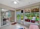 Relaxing sunroom with tiled floor, ceiling fan, and sliding doors leading to the outdoor patio area at 27003 Racquet Cir, Leesburg, FL 34748