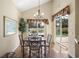 Bright dining room with chandelier, wood laminate floors and sliding glass doors to the screened pool at 2903 Blooming Alamanda Loop, Kissimmee, FL 34747