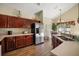 Well-appointed kitchen featuring stainless steel appliances, cherry cabinets, and wood-look floors at 2903 Blooming Alamanda Loop, Kissimmee, FL 34747