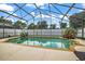 This backyard features an in-ground screened pool with beautiful surrounding plants and landscaping at 2903 Blooming Alamanda Loop, Kissimmee, FL 34747