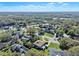 Overhead shot of a residential area with mature trees, manicured lawns, and a community pool at 2918 Cocovia Way, Leesburg, FL 34748