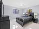 Cozy bedroom featuring stylish bed, a dresser, and two windows at 2918 Cocovia Way, Leesburg, FL 34748