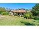 Well-maintained home featuring lovely landscaping, manicured lawn, and a view of the architectural roofline at 2918 Cocovia Way, Leesburg, FL 34748