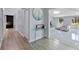 Open foyer with a glass console table, wood-look flooring and modern gray walls at 2918 Cocovia Way, Leesburg, FL 34748