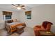 Relaxing bedroom with windows, featuring a decorative ceiling fan and comfortable seating area at 31241 Benton Dr, Eustis, FL 32736