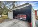 Carport featuring a truck and lawn equipment, providing protected parking and storage space at 31241 Benton Dr, Eustis, FL 32736