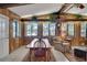 Bright dining area features wood-paneled walls, a ceiling fan, and views of the lake at 31241 Benton Dr, Eustis, FL 32736