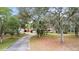 Exterior view of a home with a long driveway and mature trees at 31241 Benton Dr, Eustis, FL 32736