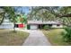 Charming single story home with a long driveway leading to a garage and additional shed-style building at 31241 Benton Dr, Eustis, FL 32736