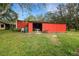 Exterior view of a red storage building on a well-maintained lawn, ideal for extra storage and workspace at 31241 Benton Dr, Eustis, FL 32736