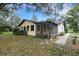 The home's backyard facade includes a screened porch, and a view of the lake at 31241 Benton Dr, Eustis, FL 32736