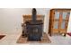 Wood burning stove on a brick hearth with vintage wooden storage cabinet at 31241 Benton Dr, Eustis, FL 32736