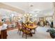 Elegant dining room with open layout, chandelier lighting, and views into the kitchen and living area at 3163 Southern Trce, The Villages, FL 32162