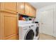 Bright laundry room with modern washer and dryer, ample cabinets, and tile flooring at 3163 Southern Trce, The Villages, FL 32162