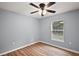 A cozy bedroom with a view, showcasing wood-look flooring and a ceiling fan at 35 Sequoia Loop Ct, Ocklawaha, FL 32179