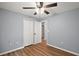 Neutral bedroom boasting a ceiling fan, wood-look flooring, and a closet for storing personal items at 35 Sequoia Loop Ct, Ocklawaha, FL 32179