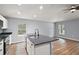 Kitchen island with stainless steel sink, granite countertop, and natural light from nearby windows at 35 Sequoia Loop Ct, Ocklawaha, FL 32179