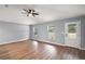 An open living room features sleek wood floors, two windows, and a glass door at 35 Sequoia Loop Ct, Ocklawaha, FL 32179