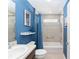 Bathroom featuring blue walls, a sink with wood cabinets, a bathtub, and a shower with a curtain at 3564 Nomad Ter, The Villages, FL 32163