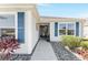 Close-up of home's entrance with decorative wreath, blue shutters, and well-maintained landscaping at 3564 Nomad Ter, The Villages, FL 32163