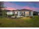 Charming single-story home with manicured lawn, lush landscaping, and a beautiful twilight sky at 3564 Nomad Ter, The Villages, FL 32163