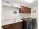 Functional laundry room with cabinets, sink, countertop space, and modern washer/dryer at 3564 Nomad Ter, The Villages, FL 32163