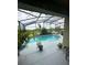 A screened pool with an outdoor lounge area overlooks a picturesque view at 3629 Maidencain St, Clermont, FL 34714