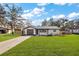 Charming renovated single-story home featuring a modern metal roof, fresh white paint, and a lush front yard at 4614 Eagles Nest Rd, Fruitland Park, FL 34731