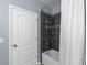 This bathroom features a shower with black tile and a white shower curtain at 481 Blue Cypress Dr, Groveland, FL 34736