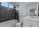 Modern bathroom with dark tile, white cabinets, and a window for natural light at 481 Blue Cypress Dr, Groveland, FL 34736