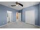 Bedroom with blue walls, neutral carpet, and an attached bathroom at 481 Blue Cypress Dr, Groveland, FL 34736