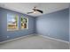 Bedroom with blue walls, neutral carpet, and lots of natural light at 481 Blue Cypress Dr, Groveland, FL 34736