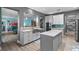 Kitchen area featuring gray cabinets, an island, stainless steel appliances, and an open view to the living room at 481 Blue Cypress Dr, Groveland, FL 34736