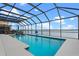 Screened-in pool provides water views, including an umbrella stand, bar, and lounge chairs at 481 Blue Cypress Dr, Groveland, FL 34736